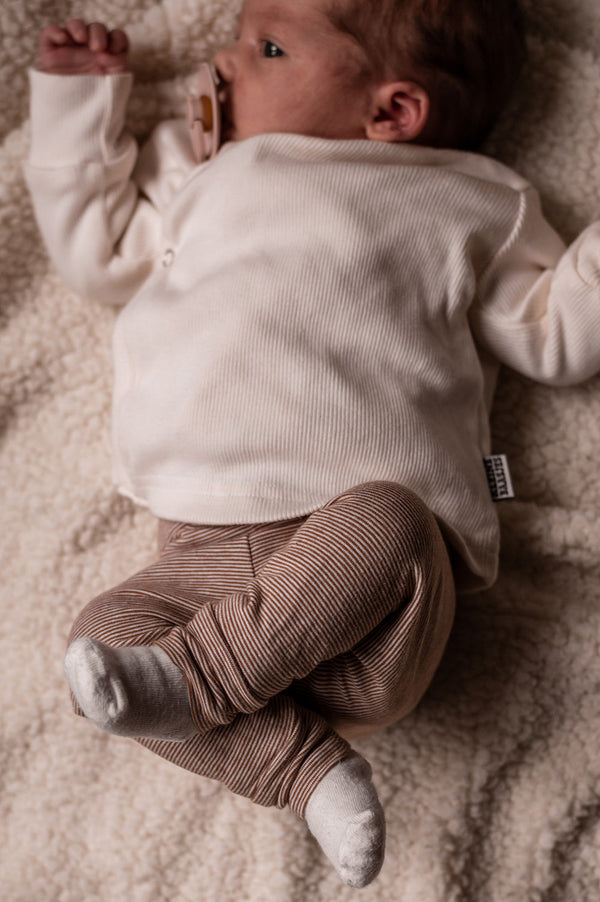 baby in handgemaakte babykleding met gestreept newborn broekje